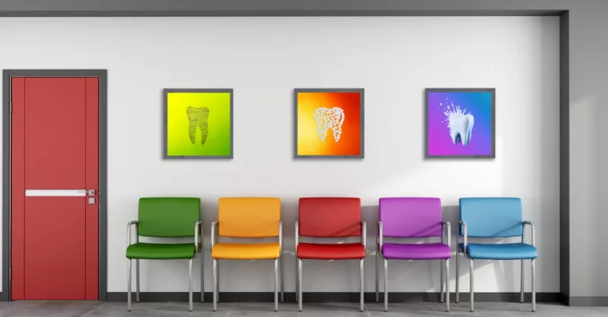 Waiting room with multi-colored chairs and three framed dental art pieces on wall