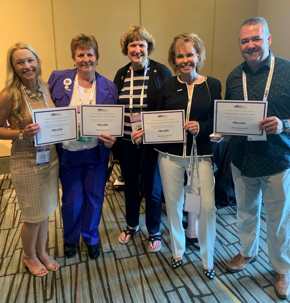 Five RDHs standing in a group holding their Fellow certificates