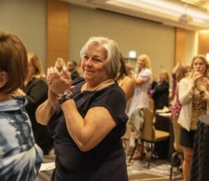 Carolynn Wahl standing and applauding