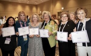 Group of newly inducted Professional Fellows hold up their certificates