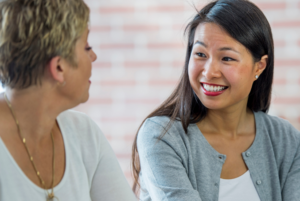 Two women side by side chatting.