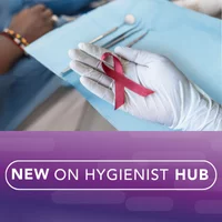 Gloved hand holding a red ribbon in an operatory