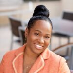 Headshot of Dr. Joy Void-Holms in a coral suit jacket