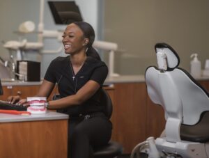 A dental hygienist sits at a computer in the clinic.
