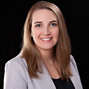 Amanda Knutt, MSDH, RDH, CST, FADHA headshot photo with grey blazer and black top.