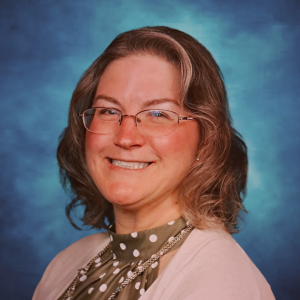 Christina Emmert RDH, PHDH, PRP, FADHA headshot photo pink sweater, polka dot blouse.