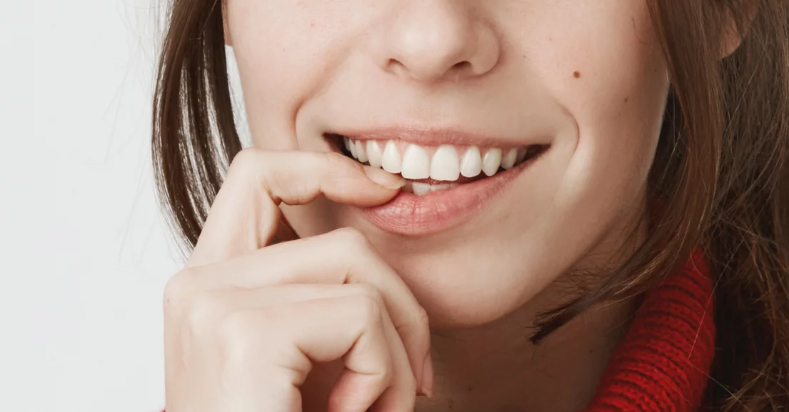 Woman with right index finger on lip