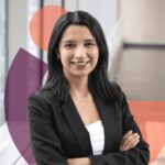 Gina Castiblanco in black jacket and white top with necklace