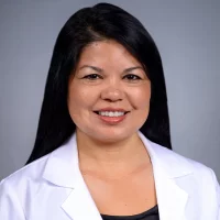 Lavina Myers, RDH, MPH, HPE in white lab coat and black top.