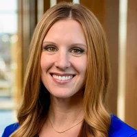 Sarah Jackson RDH, MS, FADHA in bright blue top smiling