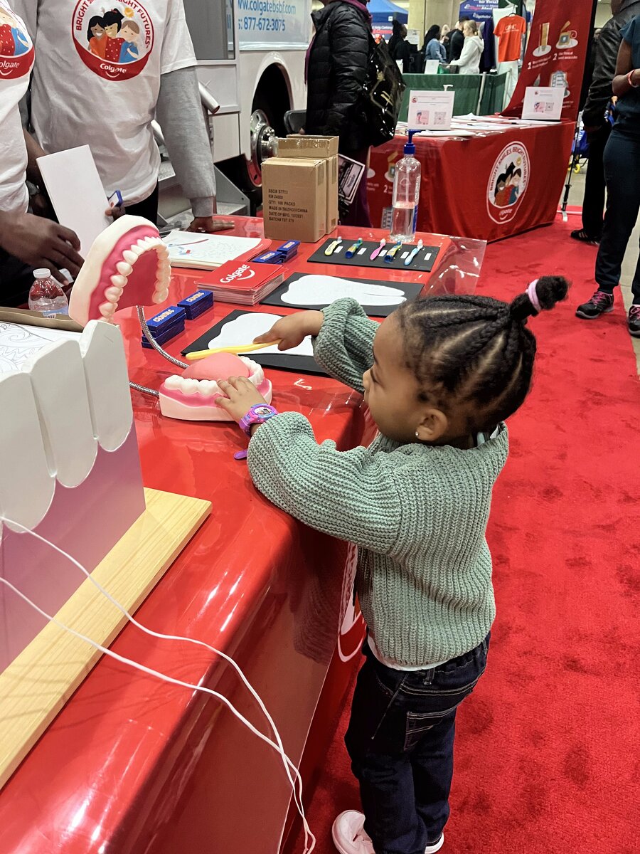 Young child practices brushing on a typodont