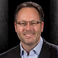Dr. Mark Donaldson BSP, RPH, PHARMD, FASHP, FACHE, smiling with glasses