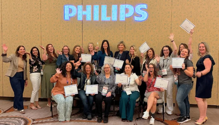 Group of Fellows with certificates pose for a picture under the Philips logo