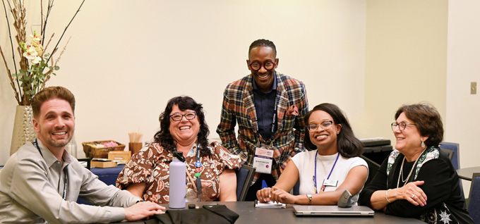 Derik Sven, Marlene Rhodes, Quardricos Driskell, Katherine Williamson and JoAnn Gurenlian smile around a conference table after an ADHA26 Informational Advocacy Session. Driskell stands behind the four seated attendees.